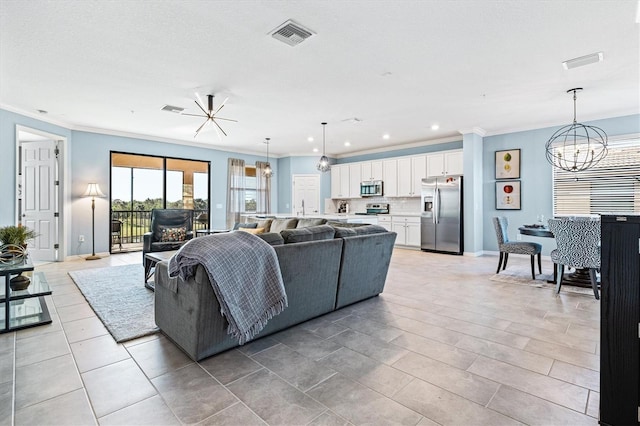 tiled living room featuring crown molding and ceiling fan with notable chandelier