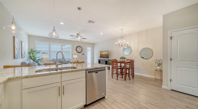 kitchen with light stone countertops, light wood-type flooring, ceiling fan with notable chandelier, sink, and dishwasher