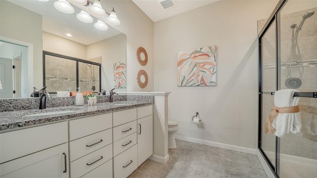 bathroom featuring tile patterned flooring, vanity, a shower with shower door, and toilet