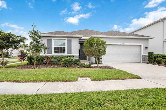 12689 Promenade Estates Blvd, Sarasota, FL 34238 - view of front of property with stucco siding, an attached garage, concrete driveway, a front lawn, and stone siding