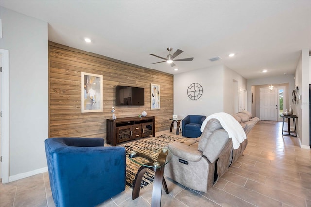 living room featuring wood walls and ceiling fan