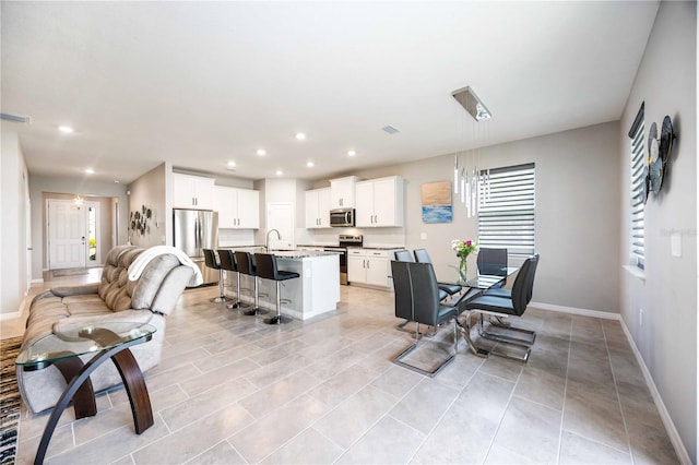 dining space featuring sink and light tile patterned floors