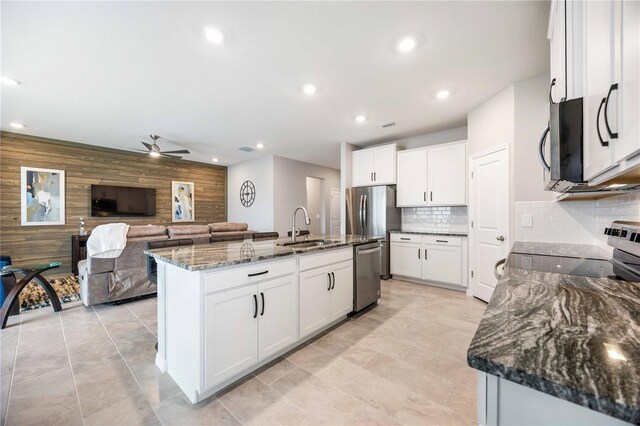 12689 Promenade Estates Blvd, Sarasota, FL 34238 - kitchen featuring stainless steel appliances, ceiling fan, dark stone counters, white cabinets, and recessed lighting