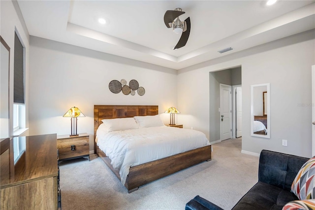 bedroom with carpet, a tray ceiling, and ceiling fan