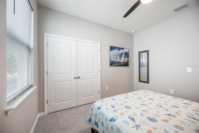 bedroom featuring light carpet, a closet, and ceiling fan