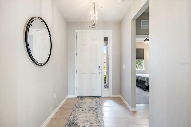 tiled entrance foyer with a notable chandelier