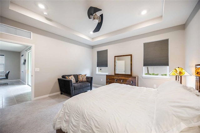 bedroom featuring carpet flooring, a raised ceiling, and ceiling fan