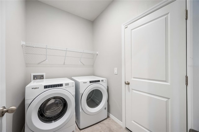 laundry room featuring washer and dryer and light tile patterned flooring