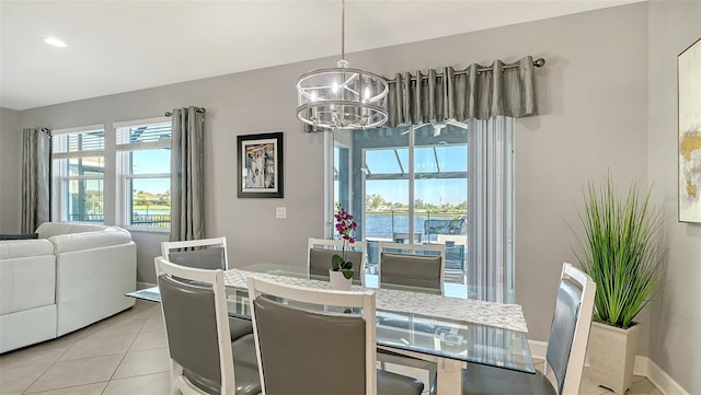 dining space with light tile patterned flooring and an inviting chandelier