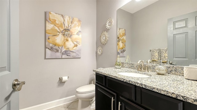 bathroom with toilet, vanity, and tile patterned floors