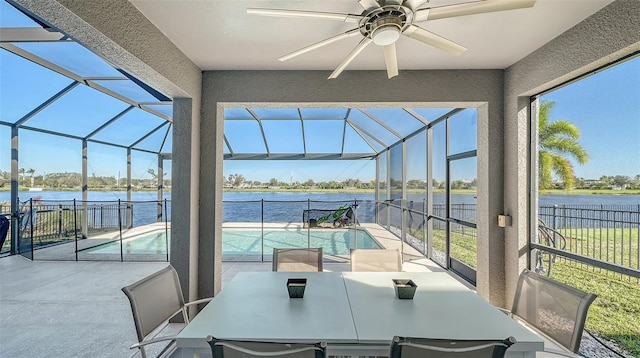 sunroom / solarium with ceiling fan and a water view