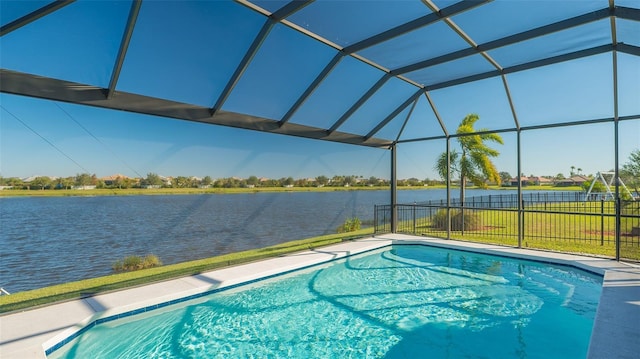 view of pool with glass enclosure, a yard, and a water view