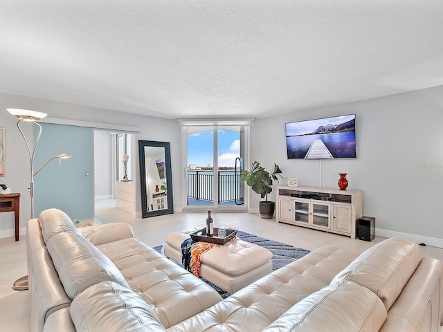 living area featuring a textured ceiling and baseboards