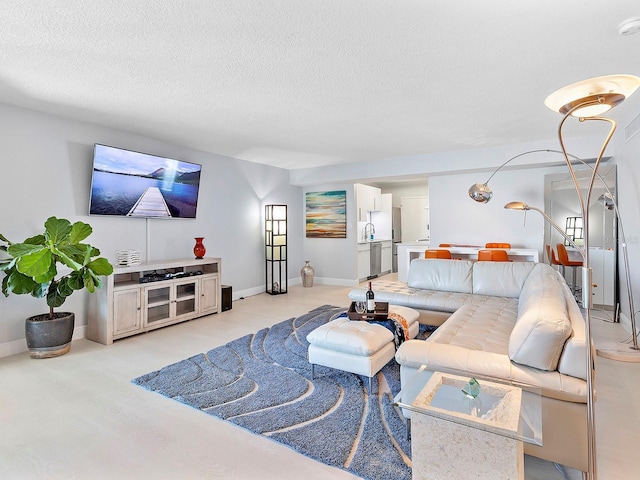 living area with baseboards and a textured ceiling