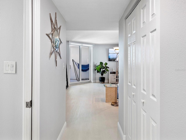 hallway with wood finished floors and baseboards