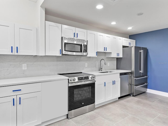 kitchen featuring a sink, appliances with stainless steel finishes, white cabinets, and light countertops