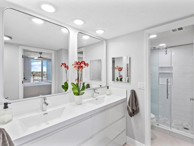 ensuite bathroom featuring a stall shower, visible vents, ensuite bathroom, and a sink