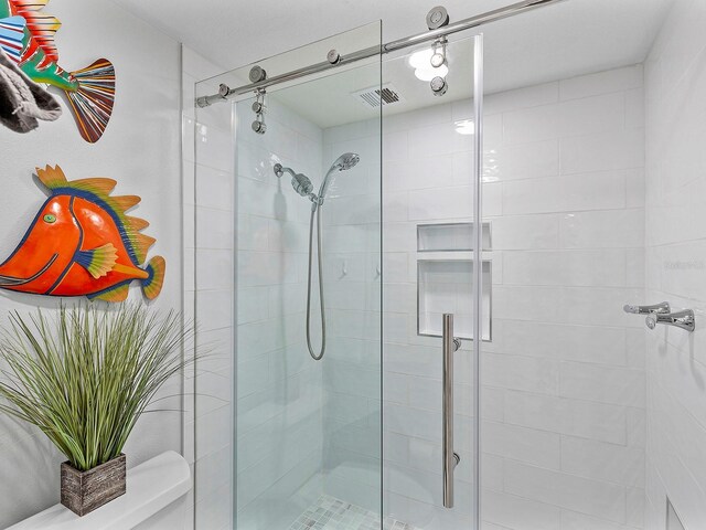 bathroom with visible vents, toilet, and a shower stall