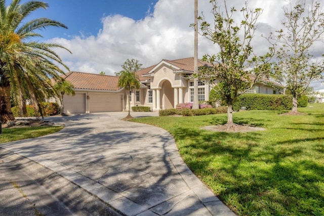 mediterranean / spanish-style house featuring a garage and a front lawn