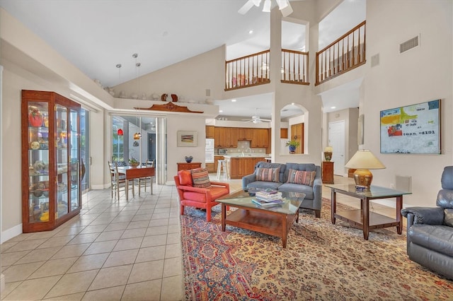 living room featuring high vaulted ceiling, ceiling fan, and light tile patterned flooring