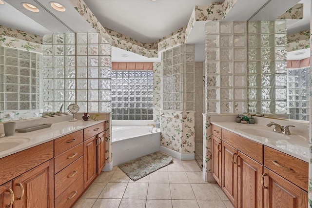 bathroom with tile patterned floors, vanity, and a tub to relax in