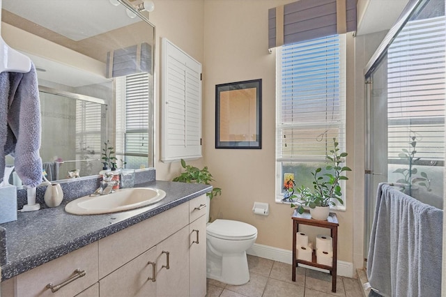 bathroom with tile patterned floors, vanity, toilet, and walk in shower