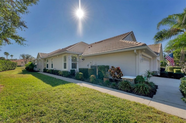 view of side of property featuring a yard and a garage