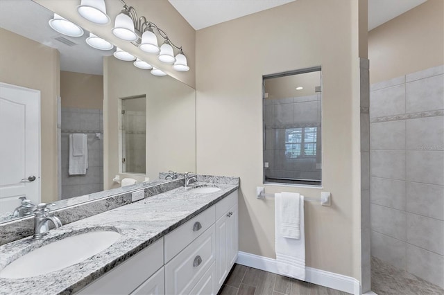 bathroom featuring tiled shower, vanity, and hardwood / wood-style flooring