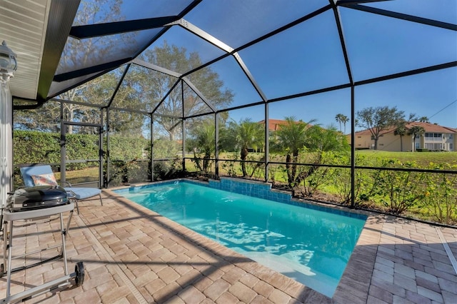 view of swimming pool featuring glass enclosure and a patio