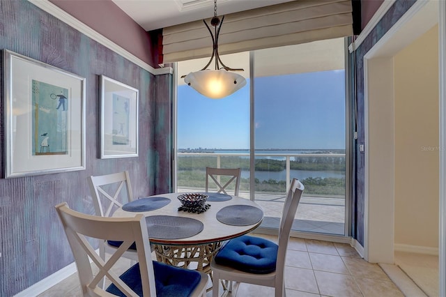 dining room featuring plenty of natural light, a water view, and light tile patterned floors