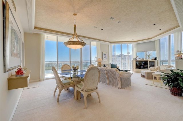 carpeted dining area with floor to ceiling windows, a tray ceiling, a wealth of natural light, and crown molding