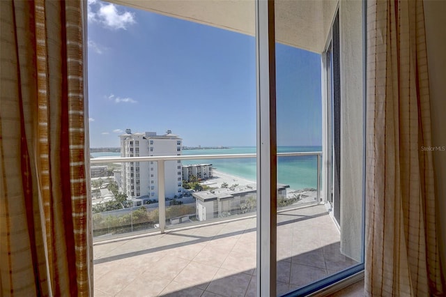 balcony featuring a view of the beach and a water view