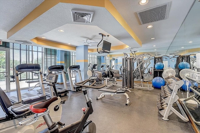 workout area featuring ceiling fan and a textured ceiling