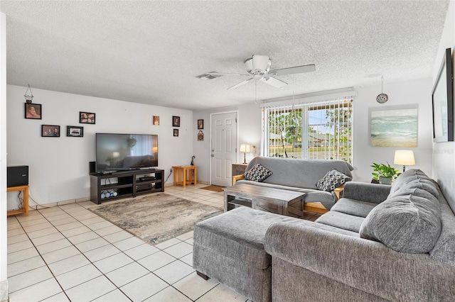 living room with a textured ceiling, ceiling fan, and light tile patterned flooring