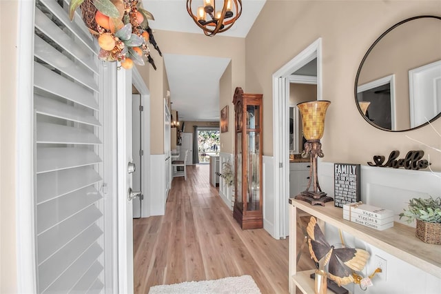 corridor featuring light hardwood / wood-style floors and a chandelier