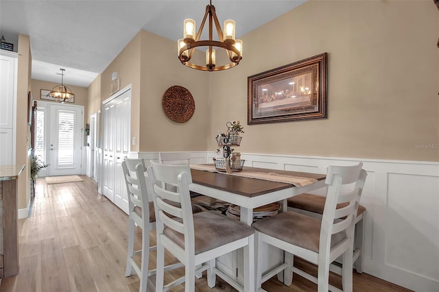 dining room with light hardwood / wood-style flooring and a chandelier