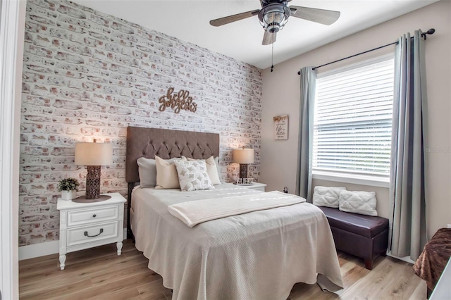 bedroom with ceiling fan, light hardwood / wood-style floors, and multiple windows