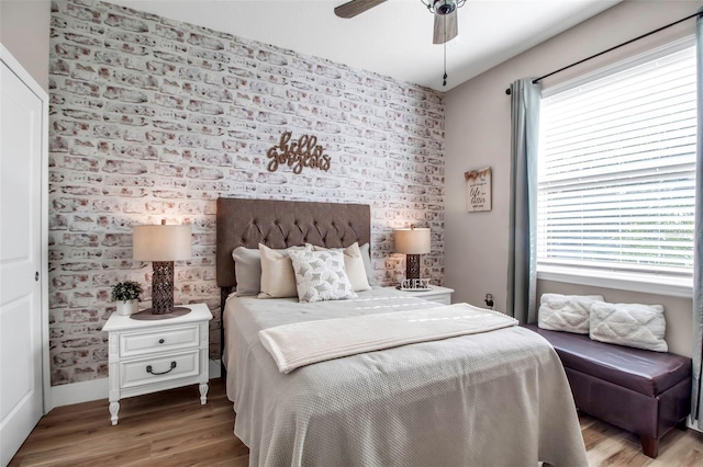 bedroom with ceiling fan, multiple windows, and wood-type flooring