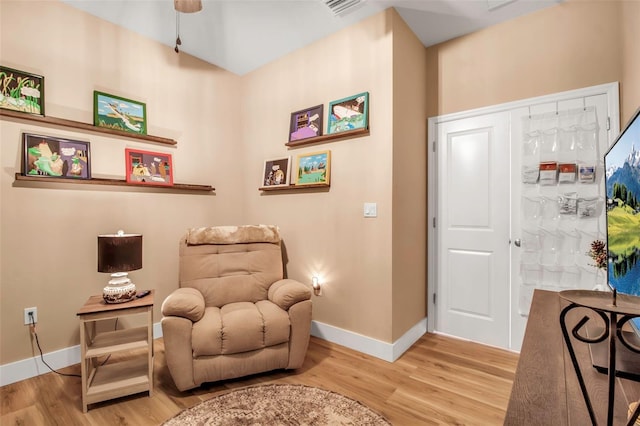 sitting room with ceiling fan and wood-type flooring