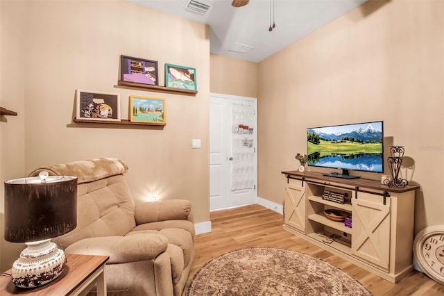 living room featuring ceiling fan and light hardwood / wood-style flooring