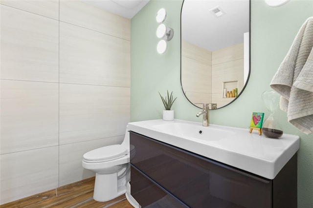 bathroom featuring toilet, vanity, and hardwood / wood-style flooring