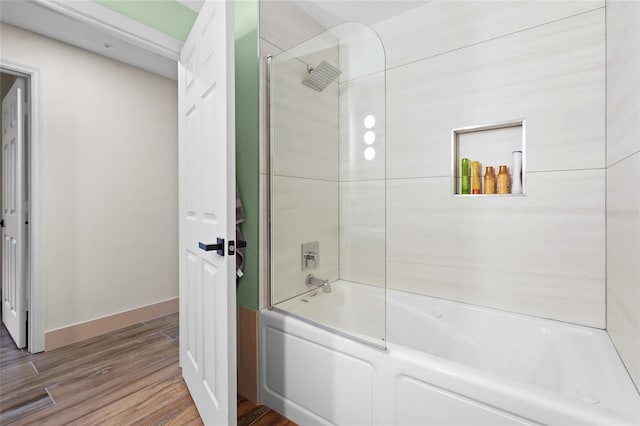 bathroom with wood-type flooring and tiled shower / bath