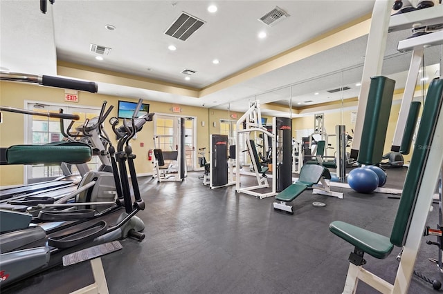 exercise room featuring french doors and a raised ceiling