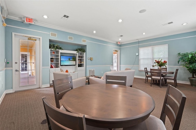 carpeted dining space with ornamental molding