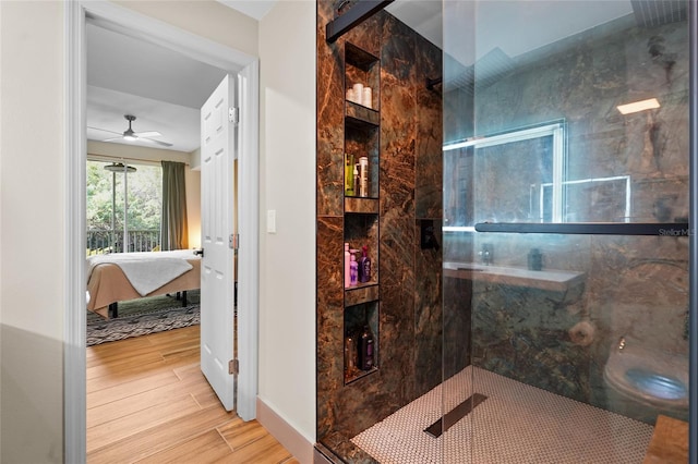 bathroom featuring ceiling fan and a shower with door