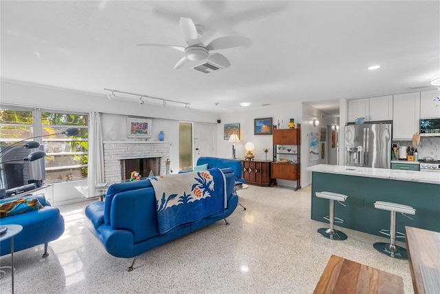 living room featuring ceiling fan and a fireplace