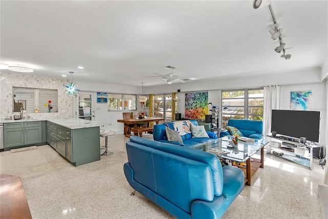 living room featuring ceiling fan and sink