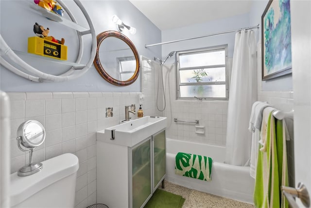 full bathroom featuring sink, shower / tub combo, tile walls, and toilet