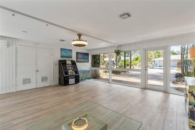 interior space with a wall mounted air conditioner and light wood-type flooring