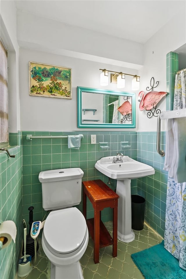 bathroom featuring tile patterned flooring, toilet, tile walls, and sink